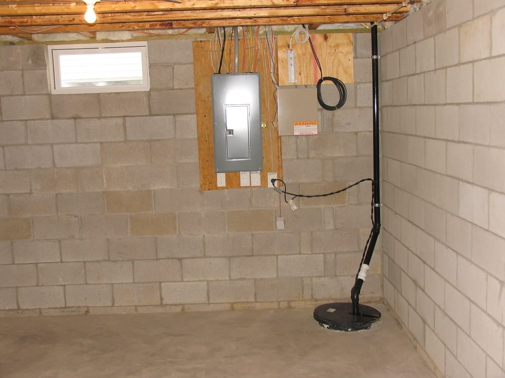 A sump pump installed in the corner of a foundation to remove water from a crawl space